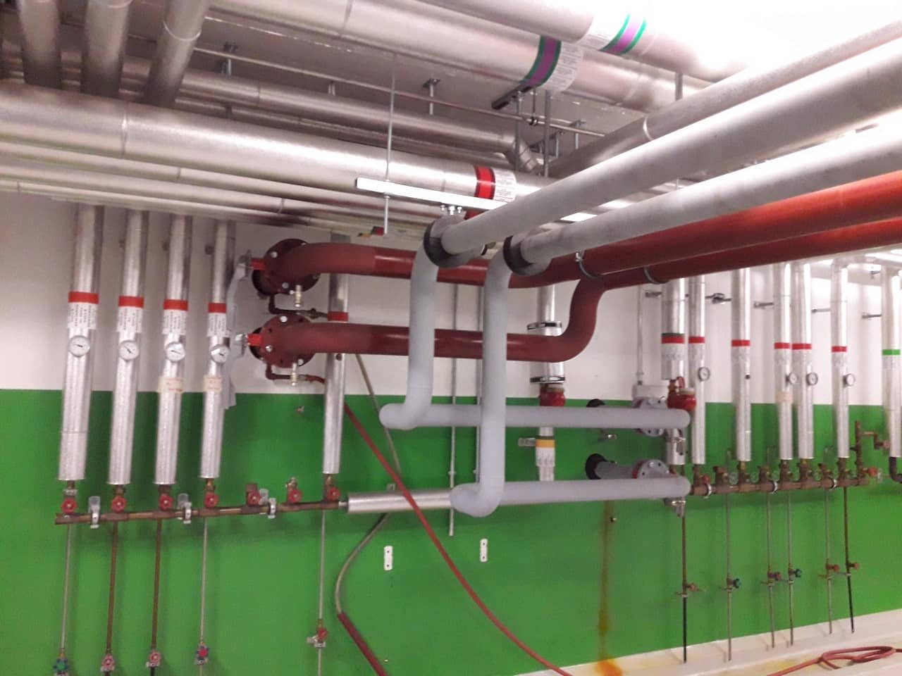 Installation tuyauterie colonnes chaud et froid dans un bâtiment international, Neotech Energies, expert chauffagiste Genève